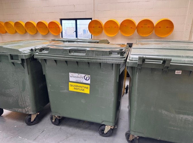 Quarantine waste bins labelled and stored inside a secure port facility for international ship waste management.